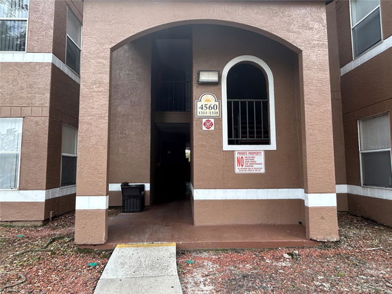 Front view of a multi-story building entrance with brown walls and white accents.