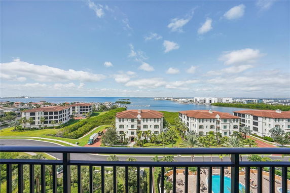 Panoramic view of a waterfront area with apartment buildings and greenery, seen from a high vantage point.
