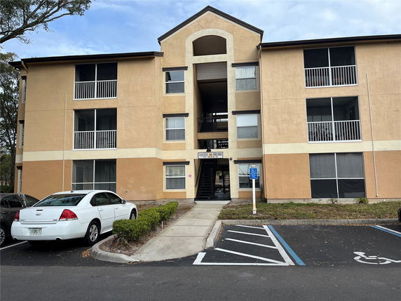 Front view of a three-story apartment building with balconies.