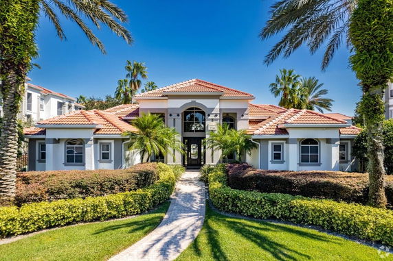 Front view of a house with red-tiled roof and arched windows.