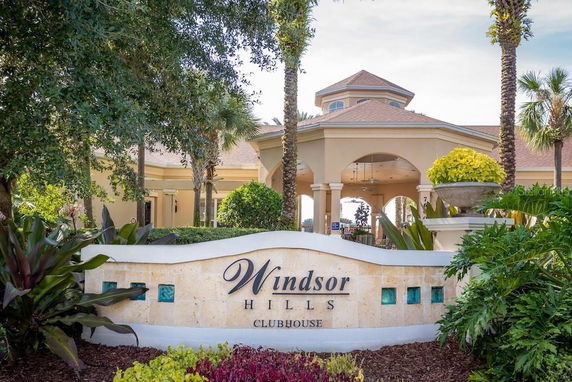 Front view of a clubhouse with a decorative entrance and surrounding greenery.