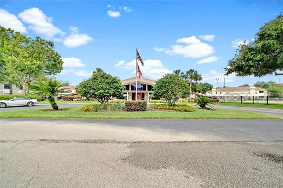 Front view of a building with a flagpole at the entrance.