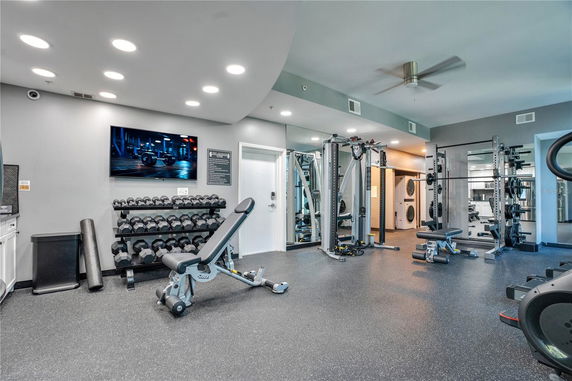 Indoor gym area with various exercise equipment and weights.