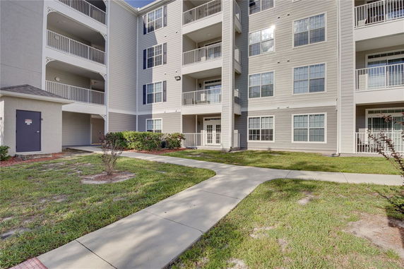 Front view of a multi-story residential building with balconies and large windows.