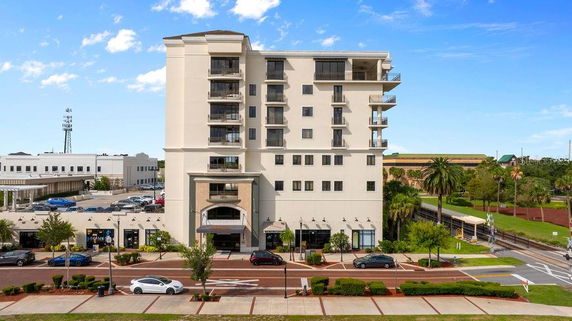 Front view of a multi-story building with balconies and a prominent entrance.