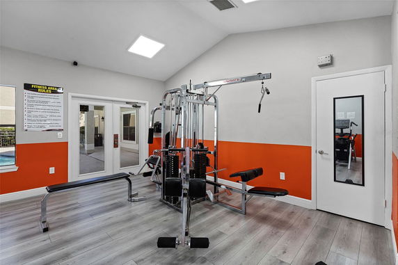 Indoor gym area with fitness equipment and orange accent wall.