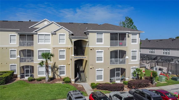 Front view of a three-story apartment building with balconies and staircase.