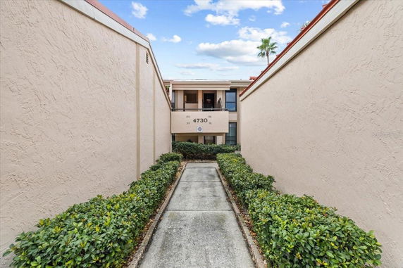 Front view of a building with multiple units and a walkway leading to it.
