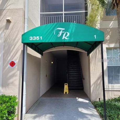Front view of a building entrance with a green awning displaying numbers 3351 and 1.