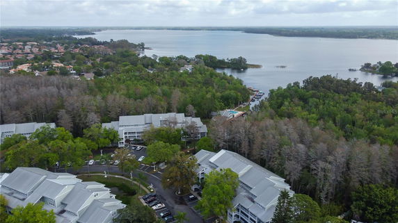 Aerial panoramic view of a residential area with buildings and a large body of water.
