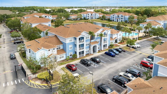 Front view of a multi-story residential building with a brown roof and blue exterior.