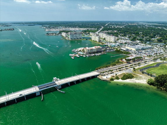 Wide view of coastal city with bridge over water and residential buildings along the shoreline.
