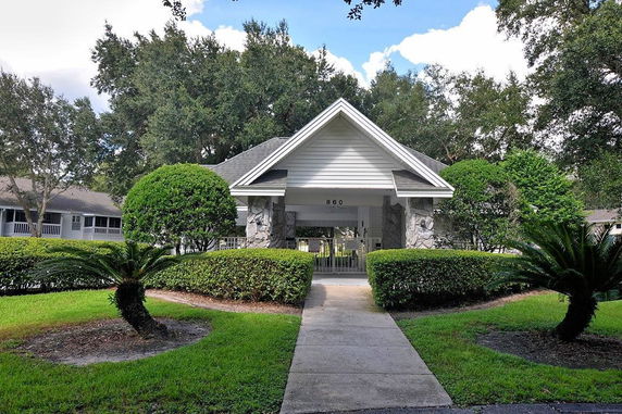 Front view of a house with stone pillars and a triangular roof.