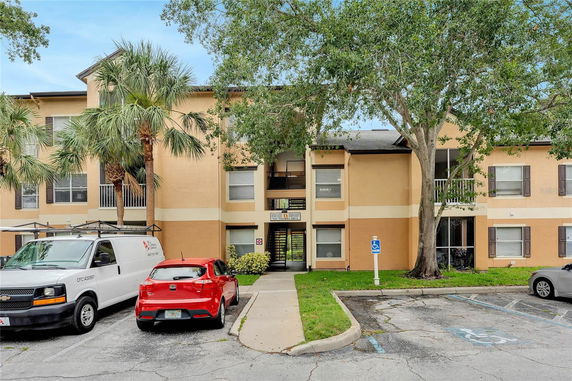 Front view of a two-story apartment building with a parking area.