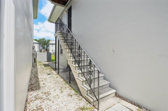 Side view of a building with an external staircase leading to an upper door.