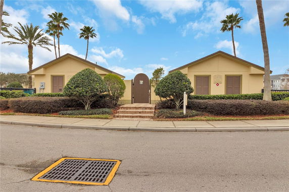 Front view of two single-story buildings with a central entry gate.