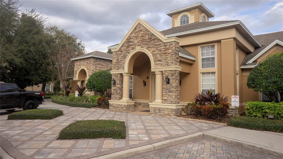 Front view of a multi-story house with an arched entrance and stone accents.
