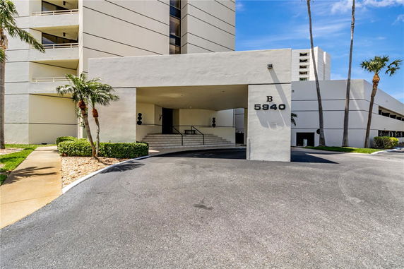 Front view of a multi-story building with entrance and stairs.