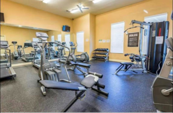 Indoor gym area with exercise equipment and mirrors.
