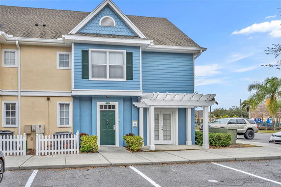 Front view of a townhouse with a blue and beige exterior and a small porch.
