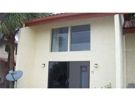 Front view of a two-story house with large windows and a satellite dish.