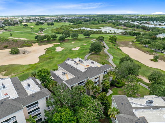 Aerial view of residential buildings adjacent to a golf course.