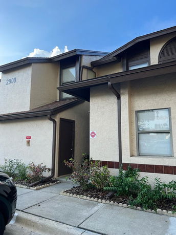 Front view of a two-story house with brown trim and beige walls.