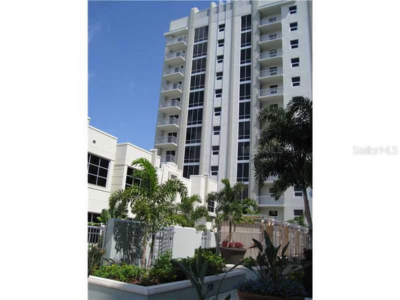 Front view of a tall, multi-story residential building with balconies.
