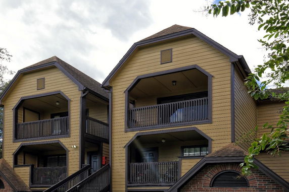 Front view of a two-story building with balconies and pitched roofs.