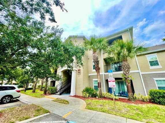 Front view of a multi-story apartment building with a staircase and balcony.