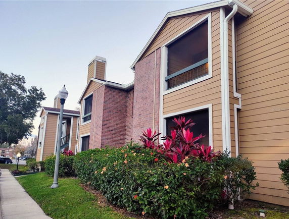 Front view of a multi-story residential building with brick and siding exterior.