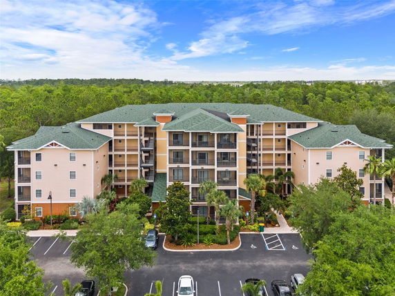 Front view of a multi-story residential building with balconies and green roofs.