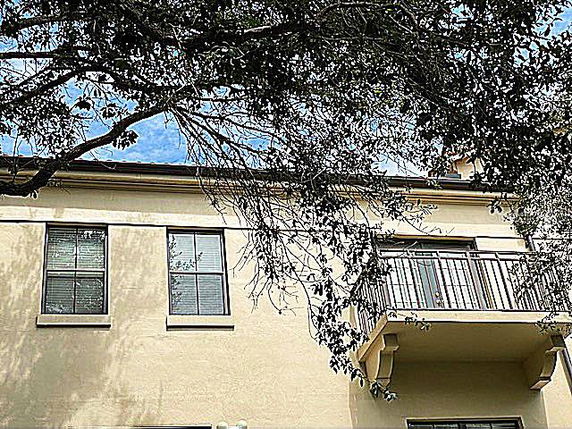 Front view of a building with a balcony and multiple windows.