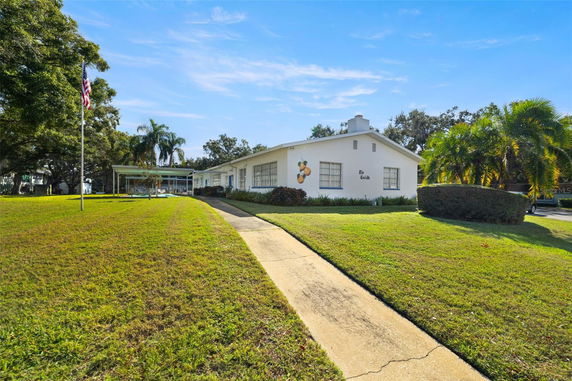 Front view of a single-story house with a side path and lawn.