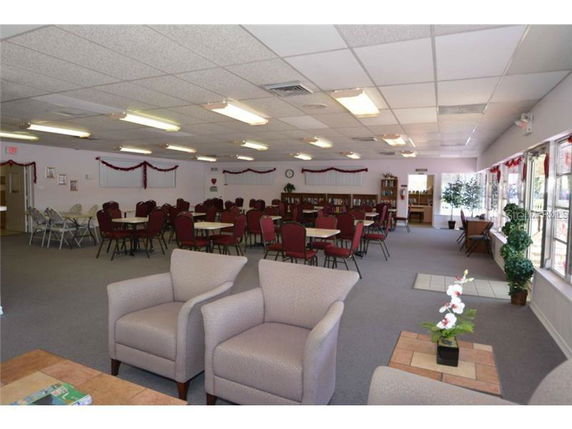 Room with chairs and tables arranged for a gathering.