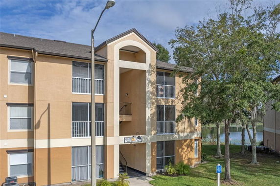 Front view of a three-story apartment building with balconies and a main entrance.