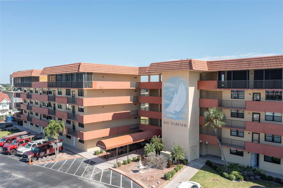 Front view of a multi-story residential building with a painted mural and covered entrance.