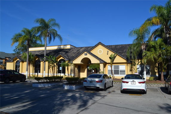 Front view of a single-story building with an arched entrance and multiple windows.