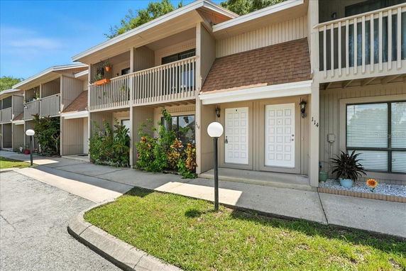 Front view of a two-story residential building with balconies and white doors.