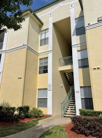 Front view of a multi-story apartment building with an external staircase.