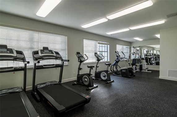 Indoor gym area with treadmills, exercise bikes, and fitness equipment.