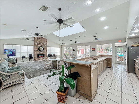 Spacious indoor area with seating and countertop space, featuring ceiling fans and large windows.