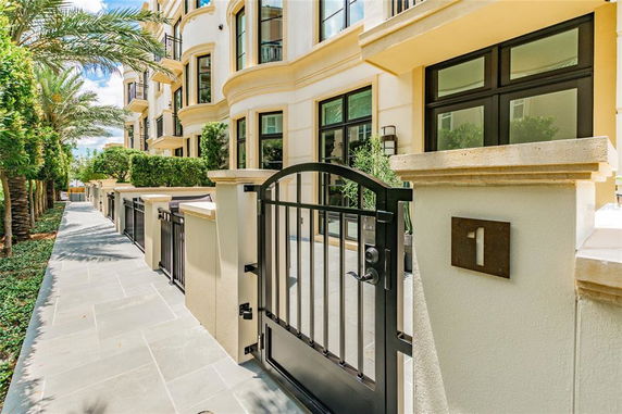 Front view of a multi-story building with gated entrance.