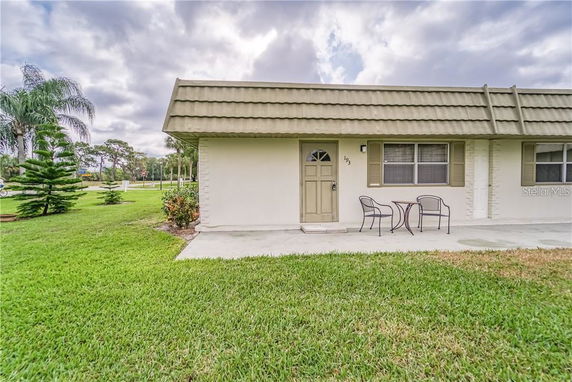 Front view of a single-story building with a patio area and small table with two chairs.