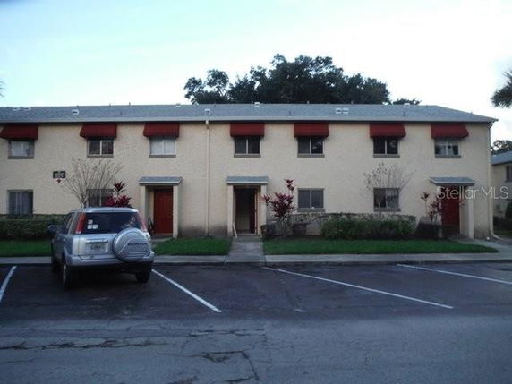 Front view of a two-story residential building with multiple units and red awnings.