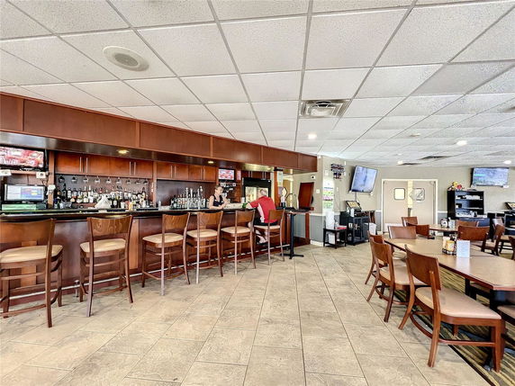 Interior of a clubhouse bar area with seating and a counter.