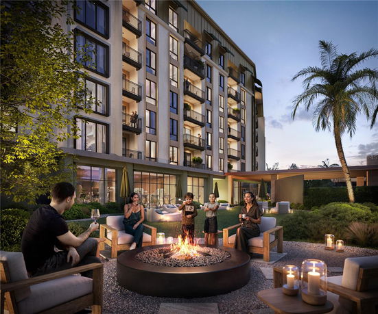 View of the front of a multi-story building with several balconies and large windows.