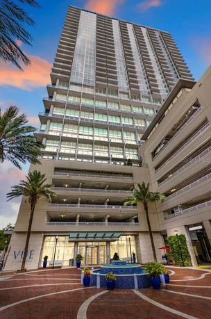 Front view of a multi-story building with a glass facade and entrance area.