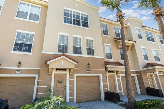 Front view of a multi-story townhouse with garage and multiple windows.