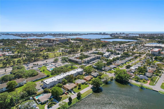 Panoramic view of a residential and commercial area with a body of water in the background.